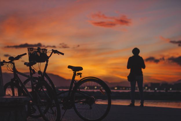 person-standing-at-bicycle-in-sunset_23-2147770869